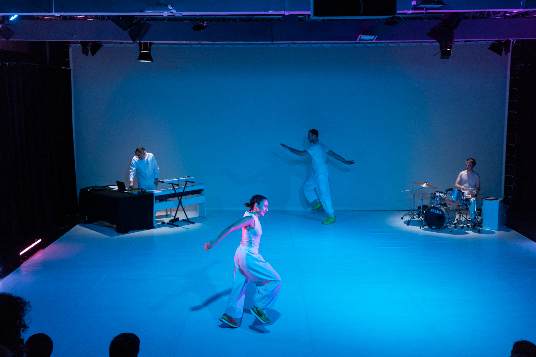 Two dancers skipping in a circle and two musicians playing on stage